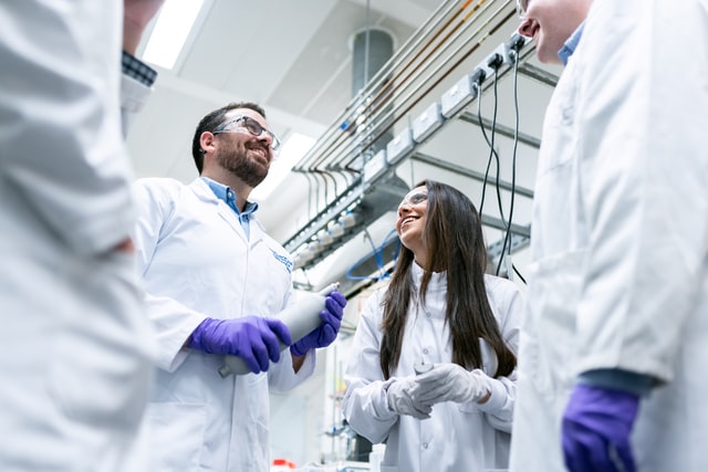 two researchers smiling and talking in a lab