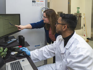PI instructing student at computer