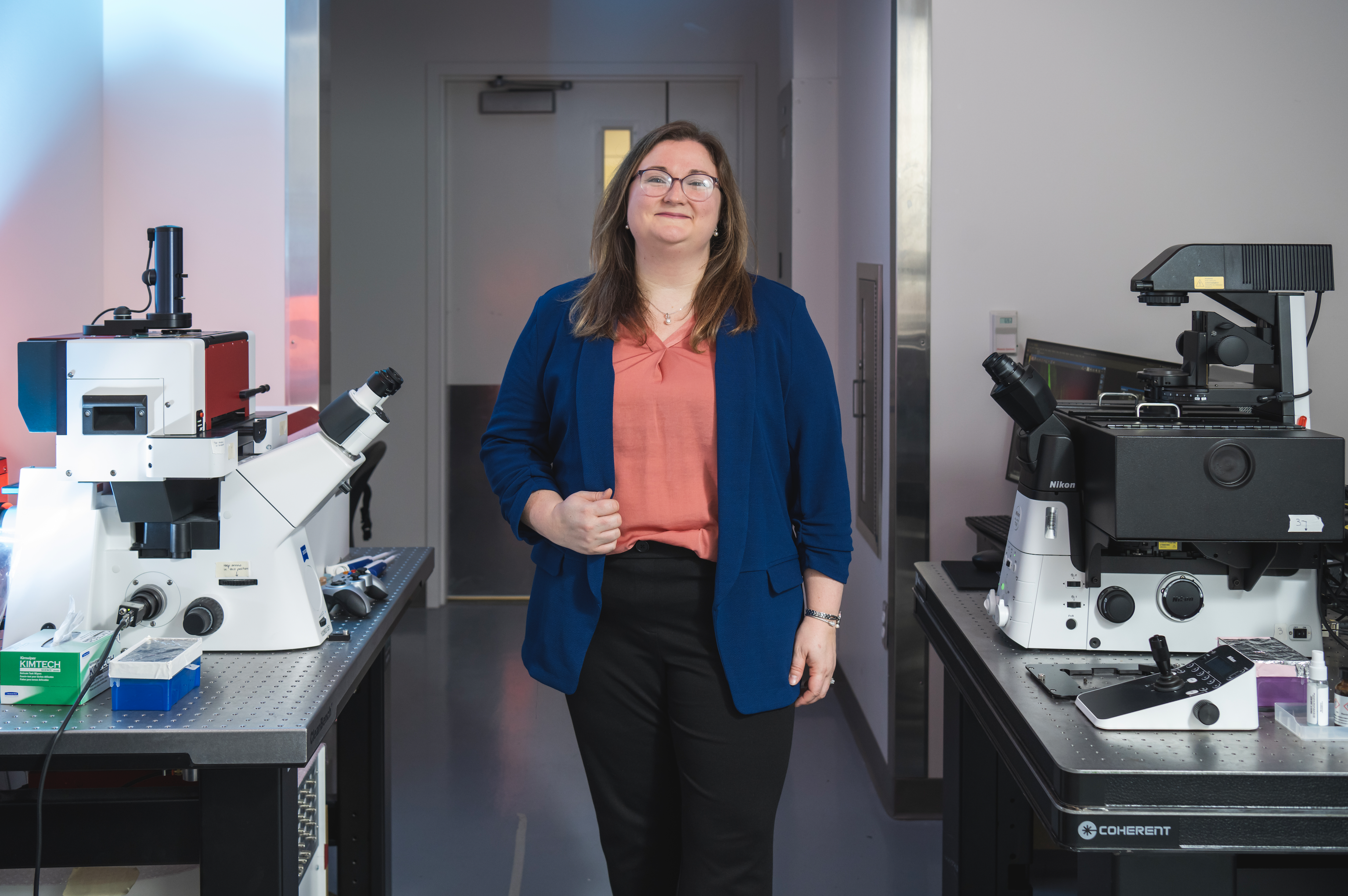 PI standing between microscopes